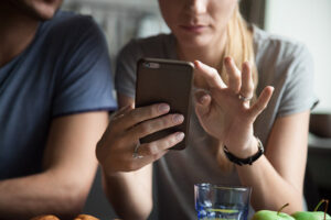 Kocasının telefonuna bakıyor.